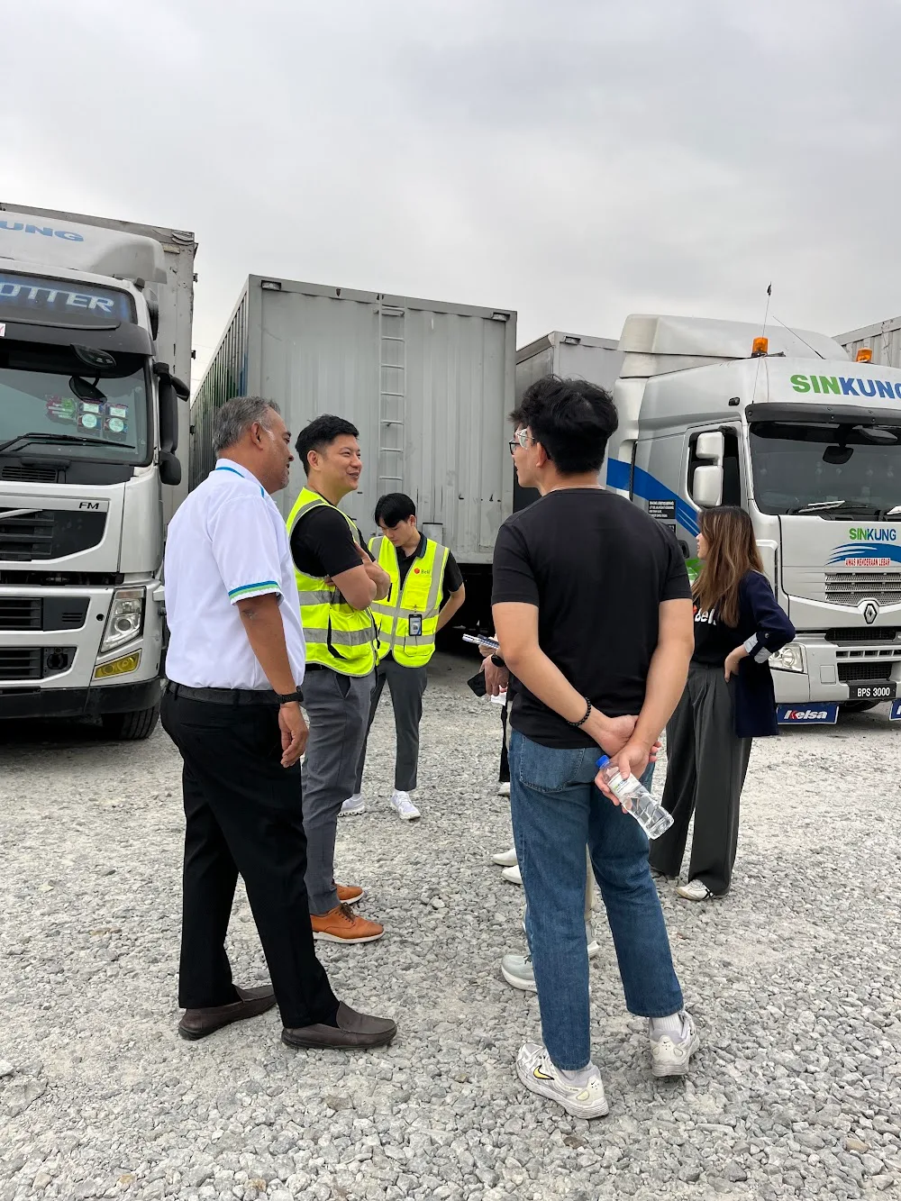 The Belli and Sin-Kung teams talking in front of Sin-Kung trucks